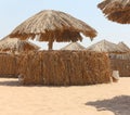 Thatched sunshades and furniture for tourists, on a yellow sand beach. Egyptian hotel beach. Royalty Free Stock Photo