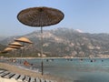 Thatched umbrella by the sea. Summer theme: beach holidays in the sun. Umbrellas on the sandy beach against the background of the Royalty Free Stock Photo