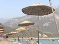 Thatched umbrella by the sea. Summer theme: beach holidays in the sun. Umbrellas on the sandy beach against the background of the Royalty Free Stock Photo