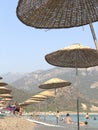 Thatched umbrella by the sea. Summer theme: beach holidays in the sun. Umbrellas on the sandy beach against the background of the Royalty Free Stock Photo