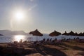 Thatched umbrellas and sun loungers by the sea during sunset. Travel by Turkey. Rest by the sea