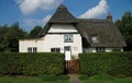 Thatched White walled Traditional Cottage with gate and hedge. Royalty Free Stock Photo