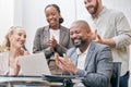 Thats amazing. a group of white collar businesspeople clapping while gathered around a laptop in the boardroom.