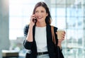 Thats awesome news. an attractive young businesswoman taking a a phonecall while walking through a modern office.