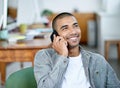 Thats awesome news. a handsome young office worker talking on a cellphone while sitting in an office.