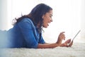 Thats awesome. a young woman browsing the web on her tablet at home.