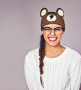 Thats so beary funny. Studio shot of a young woman wearing a brown teddy bear beanie.