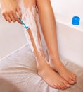 Thats a close shave. Cropped view of a woman shaving her legs.