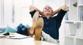 Thats enough work for the day. a cheerful mature businessman lying back and relaxing in a chair in his office. Royalty Free Stock Photo