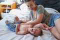 Thats ticklish, Mom. a young woman bonding with her two sons at home.