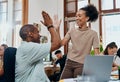 Thats why youre awesome to work with. a young businessman and businesswoman giving each other a high five while using a