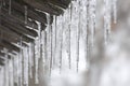 Thaw and ice melting. The icicles are melting from eaves of roof in spring. Drops of water fall of a roof. The end of winter. Royalty Free Stock Photo