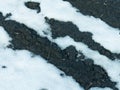 A thawed patch in the snow with black ground spring scenery. Royalty Free Stock Photo