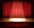 A theater stage with a red curtain, seats and a spotlight. Royalty Free Stock Photo