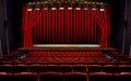 Theater stage with red curtains and seats under spotlights Royalty Free Stock Photo