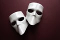 Theatre concept with the white masks on trendy vinous bordeaux, burgundy background. Anonimous, Incognito, Conspiracy concept.