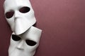 Theatre concept with the white masks on trendy vinous bordeaux, burgundy background. Anonimous, Incognito, Conspiracy concept.