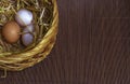 Thee easter eggs in the basket on wooden mat background
