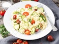 fresh diet vegetable salad with couscous, tomatoes, cucumbers, parsley, dark rustic wooden table, side view
