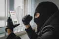 Theft of personal data. Hacking the city. A bandit in the office picks up a password to log in to a smartphone. Angry Royalty Free Stock Photo