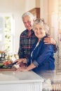 Their kitchen is seasoned with love. Portrait of a senior couple cooking together in their kitchen at home. Royalty Free Stock Photo