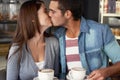 Their love knows no boundries. a young couple kissing in a cafe.