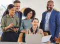 Their synergy as a team is simply amazing. Shot of a group of businesspeople working together on a laptop in an office. Royalty Free Stock Photo