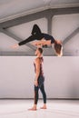 The theme of Acroyoga and Yoga Poses. A pair of two men and a woman stand in the position of asana. The guy holds the girl arched