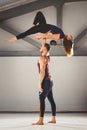 The theme of Acroyoga and Yoga Poses. A pair of two men and a woman stand in the position of asana. The guy holds the girl arched