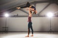 The theme of Acroyoga and Yoga Poses. A pair of two men and a woman stand in the position of asana. The guy holds the girl arched