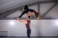 The theme of Acroyoga and Yoga Poses. A pair of two men and a woman stand in the position of asana. The guy holds the girl arched