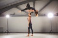 The theme of Acroyoga and Yoga Poses. A pair of two men and a woman stand in the position of asana. The guy holds the girl arched