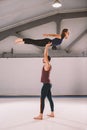 The theme of Acroyoga and Yoga Poses. A pair of two men and a woman stand in the position of asana. The guy holds the girl arched