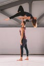 The theme of Acroyoga and Yoga Poses. A pair of two men and a woman stand in the position of asana. The guy holds the girl arched