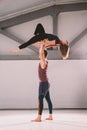 The theme of Acroyoga and Yoga Poses. A pair of two men and a woman stand in the position of asana. The guy holds the girl arched