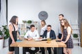 Theme is business and teamwork. A group of young Caucasian people office workers holding a meeting, briefing, working with papers Royalty Free Stock Photo
