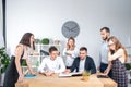 Theme is business and teamwork. A group of young Caucasian people office workers holding a meeting, briefing, working with papers Royalty Free Stock Photo