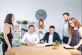 Theme is business and teamwork. A group of young Caucasian people office workers holding a meeting, briefing, working with papers Royalty Free Stock Photo