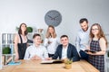 Theme is business and teamwork. A group of young Caucasian people office workers holding a meeting, briefing, working with papers Royalty Free Stock Photo