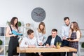 Theme is business and teamwork. A group of young Caucasian people office workers holding a meeting, briefing, working with papers Royalty Free Stock Photo