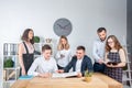 Theme is business and teamwork. A group of young Caucasian people office workers holding a meeting, briefing, working with papers Royalty Free Stock Photo