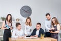 Theme is business and teamwork. A group of young Caucasian people office workers holding a meeting, briefing, working with papers Royalty Free Stock Photo