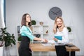 Theme business women. Two young Caucasian women business partners in formal clothes sign a contract, making a deal a handshake in Royalty Free Stock Photo