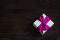 Theme of celebrations and gifts: exclusive gift Packed in white box with purple ribbon, beautiful and expensive gift on dark woode