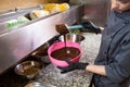 Theme cooking chocolate. Close-up of a hand. Young Caucasian woman cook with tattoo and in uniform prepares to make hot thick