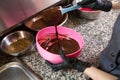 Theme cooking chocolate. Close-up of a hand. Young Caucasian woman cook with tattoo and in uniform prepares to make hot thick