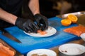 Theme cooking is a profession of cooking. Close-up of a Caucasian man`s hand in a restaurant kitchen preparing red fish fillets Royalty Free Stock Photo