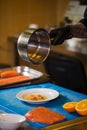 Theme cooking is a profession of cooking. Close-up of a Caucasian man`s hand in a restaurant kitchen preparing red fish fillets