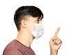 Theme of coronavirus and safety. A young man in a mask from a virus shows a finger with a threat. Horizontal frame Royalty Free Stock Photo