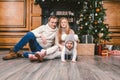 Family holiday New Year and Christmas. Young caucasian family mom dad son 1 year sit wooden floor near fireplace christmas tree on Royalty Free Stock Photo